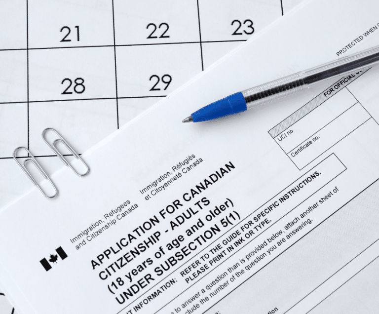 Application form for Canadian citizenship with a pen on top.