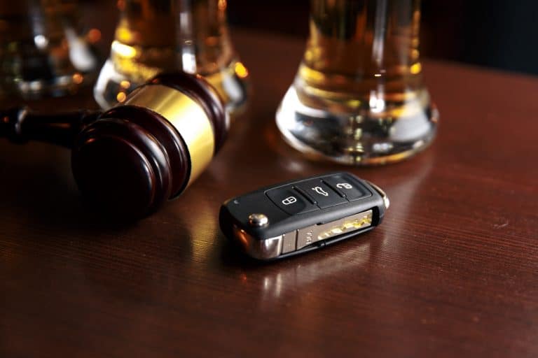 A wooden gavel and a car key fob on a table, suggesting legal implications related to driving in Canada and the issue of criminal inadmissibility due to DUI.