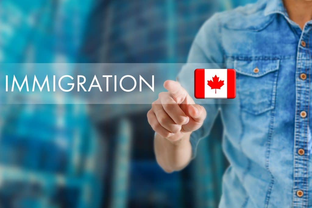 Person interacting with a digital interface displaying the word "immigration" and the Canadian flag, managed by Canada immigration consultants.