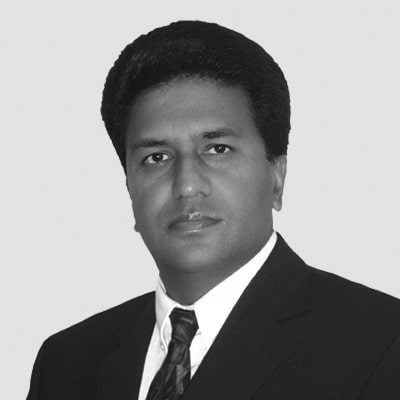 Black and white portrait of Balvinder Pahl LLb (Hons) RCIC Regulated Canadian Immigration Consultant , a man in a suit and tie.